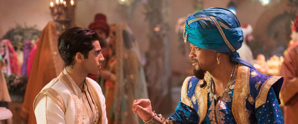 Genie (Will Smith) talks to Aladdin (Mena Massoud) about how to talk to Princess Jasmine (Naomi Scott). Image courtesy of Disney
